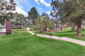 Lakewood apartment for rent - A grassy area with a pathway and trees in the background.