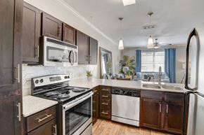 Hurst apartment for rent - an updated kitchen with stainless steel appliances and wooden cabinets