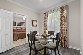 Houston apartment for rent - a dining room with a table and chairs and a bedroom with a bed