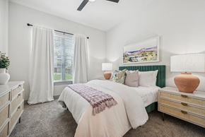 Waxahachie apartment for rent - a bedroom with a bed and a window with white curtains