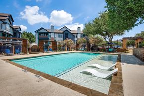 Irving apartment for rent - A swimming pool surrounded by a fence and chairs.