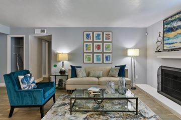 Fort Worth apartment for rent - A living room with a blue chair and a glass coffee table.