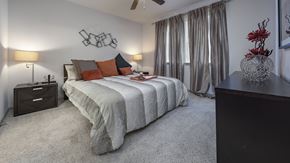 Pearland apartment for rent - a bedroom with a bed and a dresser and a window