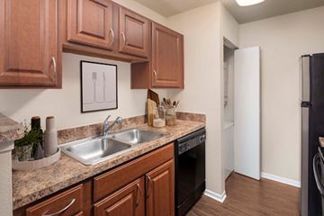 Irving apartment for rent - A kitchen with brown cabinets and a white refrigerator.