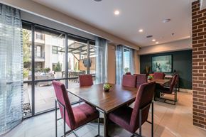 Plano apartment for rent - A seating area with a table and chairs facing a swimming pool.