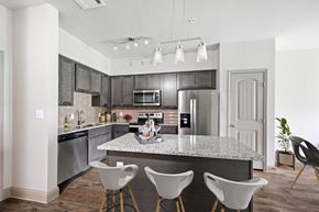 Burleson apartment for rent - a kitchen with a large island with four chairs around it