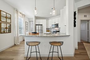 Azle apartment for rent - an open kitchen with bar stools in front of a granite counter top