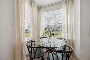 Azle apartment for rent - a dining room with a glass table and three chairs in front of a window