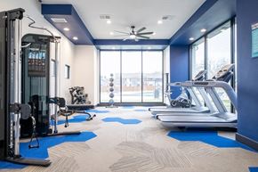 Arlington apartment for rent - a gym with treadmills and other exercise equipment and a large window