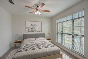 Conroe apartment for rent - a bedroom with a bed and a ceiling fan