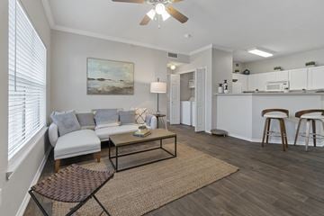 Denton apartment for rent - A living room with a white couch and a painting on the wall.