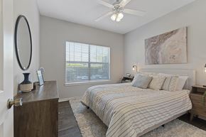 Denton apartment for rent - A bedroom with a large bed and a ceiling fan.