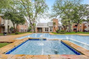 New Braunfels apartment for rent - a swimming pool with a fountain in front of an apartment building