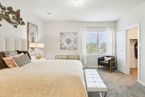 Princeton triplex for rent - A bedroom with a large bed and a chair by the window.