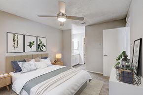 New Braunfels apartment for rent - our apartments offer a bedroom with a large bed and a ceiling fan