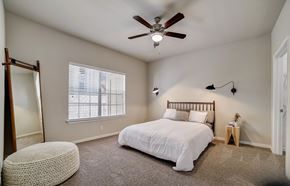San Antonio apartment for rent - A bedroom with a bed, a ceiling fan, and a window with blinds.