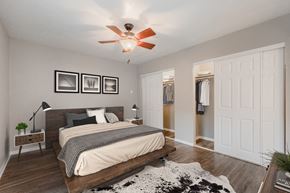 Denton townhouse for rent - a bedroom with a large bed and a ceiling fan
