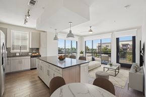 Plano apartment for rent - A modern kitchen with a large granite island and a view of Plano, Texas.