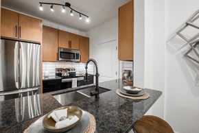 Austin apartment for rent - Kitchen island with granite countertop, undermount sink, and stainless steel appliances.