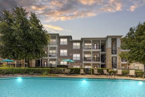 Denton apartment for rent - A large apartment complex with a pool in the foreground.