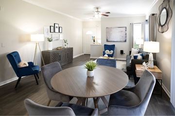 Houston apartment for rent - A living room with a round table and blue chairs.