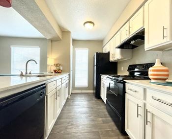 Kitchen with white cabinets and black appliances
