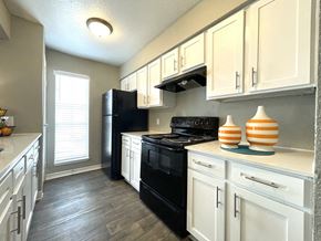 Houston apartment for rent - Galley kitchen with white cabinets and black appliances1 at The Alara Apartments, Houston, 77060