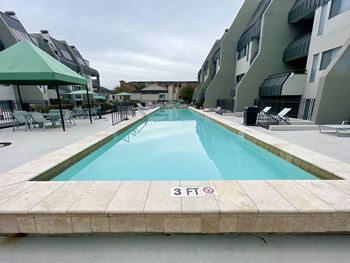 Swimming pool with green umbrellas and lounge chairs