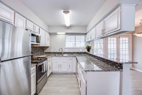 Houston apartment for rent - A kitchen with white cabinets and a granite countertop.