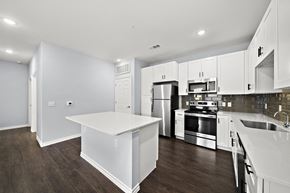 Houston apartment for rent - a large kitchen with white cabinets and stainless steel appliances