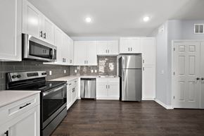 Houston apartment for rent - a renovated kitchen with white cabinets and stainless steel appliances