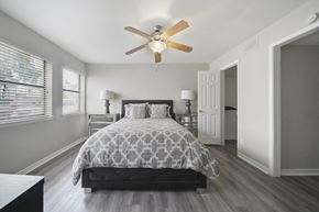 Houston apartment for rent - A bedroom with a bed, dresser, and a ceiling fan.