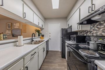 Killeen apartment for rent - A kitchen with a black stove top oven and a white counter top.