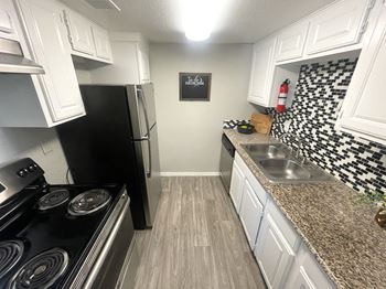 Updated kitchen with white cabinets and mosaic backsplash