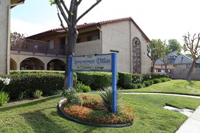 Fontana apartment for rent - A sign for Arrowcrest Dillas stands in front of a building.