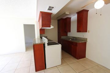 Loma Linda apartment for rent - A kitchen with red cabinets and a white counter.