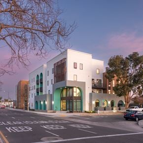 Santa Ana townhouse for rent - A white building with a green trim is on a street corner.