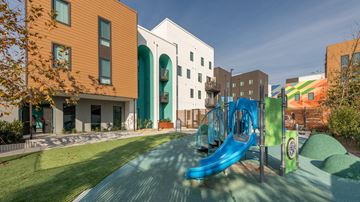 Santa Ana townhouse for rent - A playground with a blue slide and a green hill.