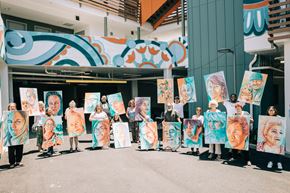 Santa Ana apartment for rent - A group of people holding up paintings of women's faces.