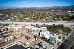 Santa Ana apartment for rent - A view of a city from above with buildings, roads, and cars.