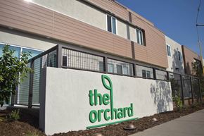 Santa Ana townhouse for rent - The Orchard building has a white sign with green lettering.