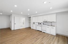 Costa Mesa apartment for rent - A kitchen with white cabinets and wooden floors.