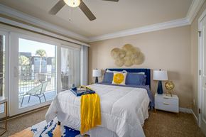 Houston apartment for rent - a bedroom with a large bed and a ceiling fan