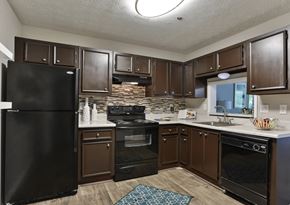 Stone Mountain apartment for rent - A kitchen with black appliances and brown cabinets.