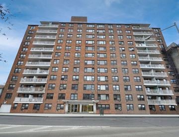 Bronx apartment for rent - A large red brick building with many windows and balconies.