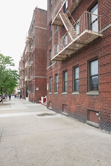 Bronx apartment for rent - A long brick building with a fire escape.