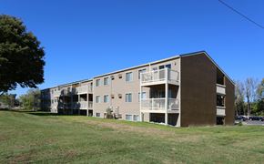 Columbus apartment for rent - A large apartment building with a grassy area in front.