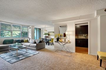 Cherry Hill apartment for rent - A living room with a grey sofa and a glass coffee table.