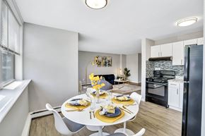 Maple Shade apartment for rent - A modern dining room with a white table set for two.