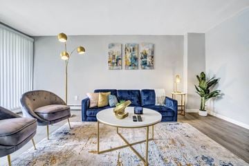 Maple Shade apartment for rent - A living room with a blue couch and a gold floor lamp.